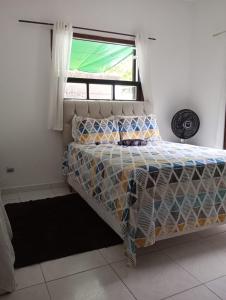 Bett in einem Zimmer mit Fenster in der Unterkunft Casa da Praia da Adriana in Ubatuba