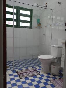 ein Badezimmer mit einem WC und einem blauen und weißen Fliesenboden in der Unterkunft Casa da Praia da Adriana in Ubatuba