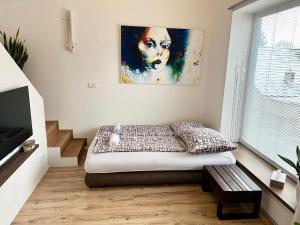 a bedroom with a bed and a painting on the wall at Apartment Brno- BBQ terrace in Husovice