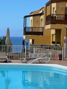 a swimming pool in front of a building at Aloha Apartman Arguineguin in Arguineguín
