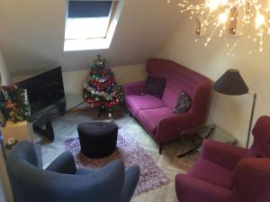 una sala de estar con un árbol de Navidad y muebles morados en 2 Bedroom Furnished Apartment in a Rural Position en Stone
