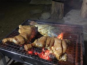 two pieces of meat cooking on a grill at The Vintage Villa - Knuckles in Rangala