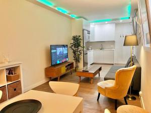a living room with a couch and a tv and a kitchen at Apartamentos Chamberí in Madrid
