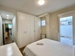 1 dormitorio con cama blanca y ventana en Apartamentos Chamberí, en Madrid