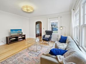 a living room with a couch and a glass table at Cozy 3br Home By Ingersoll Restaurant Scene in Des Moines