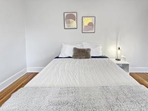 a white bedroom with a large bed with white sheets at Cozy 3br Home By Ingersoll Restaurant Scene in Des Moines