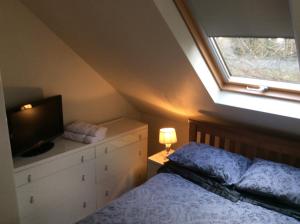 a bedroom with a bed with a television and a window at 2 Bedroom Furnished Apartment in a Rural Position in Stone
