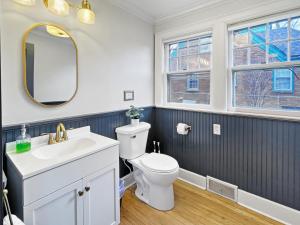 a bathroom with a white toilet and a sink at Cozy 3br Home By Ingersoll Restaurant Scene in Des Moines +15 photos