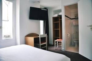 a bedroom with a bed and a desk at Hotel de la Tour in Paris
