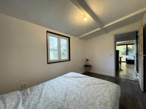 een witte slaapkamer met een bed en een raam bij Charmante maison avec extérieur in La Queue-en-Brie