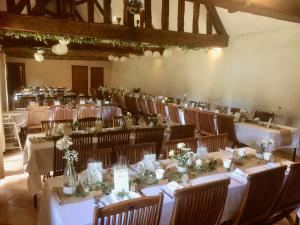 a banquet hall with tables and chairs with flowers on them at La Ferme au colombier in NÃ©ron