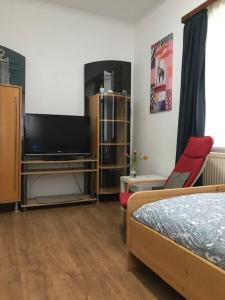 a bedroom with a tv and a bed and a tv stand at Monteurzimmer Ostalb in Lauchheim
