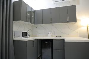 a kitchen with gray cabinets and a white microwave at روز نجد للشقق الفندقية in Riyadh