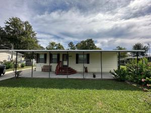 a small white house with a screened in porch at Waterfront Canal in Satsuma Florida in Satsuma