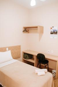- une chambre avec deux lits, un bureau et une chaise dans l'établissement Rancho das Pedras Itaberá, à Itaberá