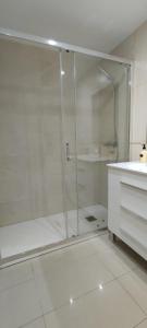 a glass shower in a white bathroom with a sink at Apartamento Vistas al mar en Gemelos 24 La Cala de Finestrat in Alicante