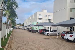 eine Reihe von Autos auf einem Parkplatz mit Sonnenschirmen geparkt in der Unterkunft Apartamento no Ilha Bela 2 in Caldas Novas