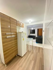 eine Küche mit einem Kühlschrank und einem Tisch im Zimmer in der Unterkunft Apartamento no Ilha Bela 2 in Caldas Novas