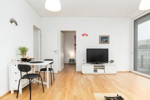 a white living room with a table and a tv at Relaxed Zen-Apartment in top area and amazing view in Vienna