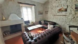 uma sala de estar com um sofá de couro e uma lareira em Gîte La Ribeyrette em Chamborigaud