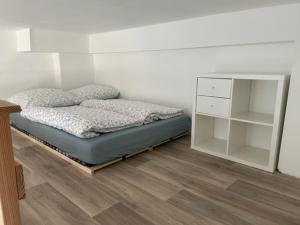 a bedroom with a bed and a white cabinet at Grindelzimmer in Hamburg
