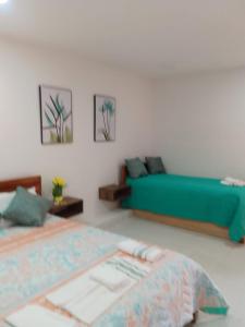 una camera con un letto verde e un divano di Habitaciones Ciudad Amurallada a Cartagena de Indias