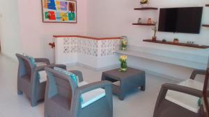 un soggiorno con sedie, tavolo e TV di Habitaciones Ciudad Amurallada a Cartagena de Indias