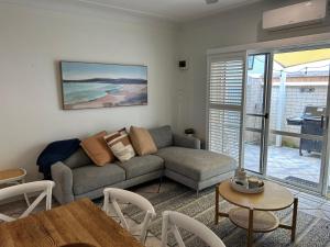 a living room with a couch and a table at Bahia by the Beach in Avoca Beach