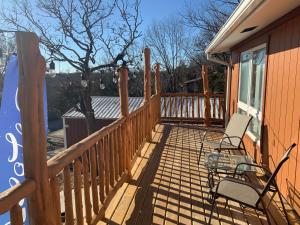 une terrasse en bois avec deux chaises sur une maison dans l'établissement Cedar House, à Rockaway Beach