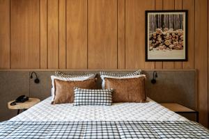 um quarto com uma cama com um cobertor xadrez em Hotel Alpestre em Gramado