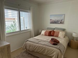 a bedroom with a bed with two towels on it at Bahia by the Beach in Avoca Beach