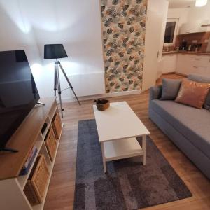 uma sala de estar com um sofá e uma mesa em TYVAC - Maison centre Plougasnou 2 chambres- 4 voyageurs em Plougasnou