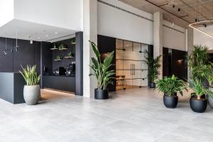 eine Lobby mit Topfpflanzen an den Wänden in der Unterkunft Trafford Suite Modern 1 bed with cinema room in Manchester