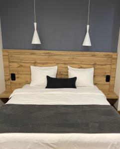 a large bed with two black pillows on it at SCANDIC apartments-feels like home! in Lviv +11 photos
