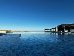 una piscina con azulejos azules en el agua en Linda Bay Spa Apartments, en Mar de las Pampas