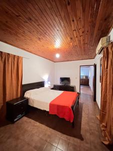 sypialnia z łóżkiem i drewnianym sufitem w obiekcie Dorbozy w mieście Wanda