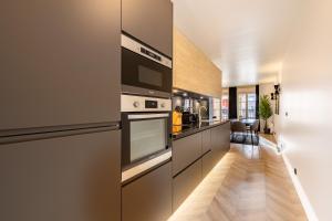uma cozinha com electrodomésticos em aço inoxidável e pisos em madeira em Suite d'Exception, Disneyland Paris, 6 personnes em Serris
