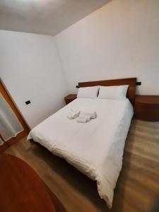 a bedroom with a white bed with two towels on it at Appartamento Torrefranca in Trento