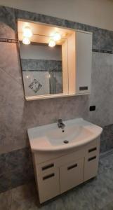a bathroom with a white sink and a mirror at Appartamento Torrefranca in Trento