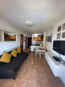 sala de estar con sofá y TV en Mara apartment with beautyful oceanview, en Playa de las Américas