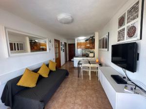 een woonkamer met een bank en een flatscreen-tv bij Mara apartment with beautyful oceanview in Playa de las Americas
