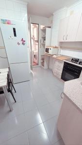 a white kitchen with a refrigerator and a stove at El rincón exquisito in Albacete