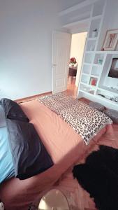Dormitorio con cama con almohada de estampado de leopardo en El rincón exquisito en Albacete