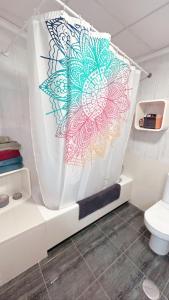 uma cortina de chuveiro na casa de banho com WC em El rincón exquisito em Albacete