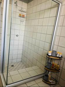 La salle de bains est pourvue d'une douche avec une porte en verre. dans l'établissement Kganya@Sunset Lodge, à Phalaborwa