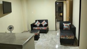 salon z 2 krzesłami i kanapą w obiekcie JEG Estudios Vacacionales w mieście Montenegro
