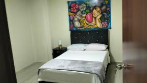 sypialnia z łóżkiem z obrazem na ścianie w obiekcie JEG Estudios Vacacionales w mieście Montenegro