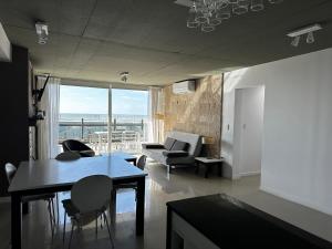 una sala de estar con una mesa y un sofá en Linda Bay Spa Apartments, en Mar de las Pampas