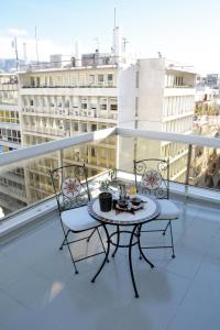 einen Tisch und zwei Stühle auf dem Balkon in der Unterkunft Arethusa Hotel in Athen
