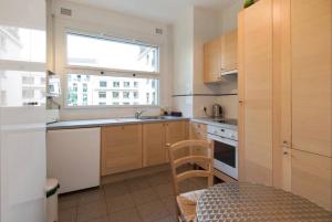 a kitchen with wooden cabinets and a window and a sink at Avenue Montaigne Paris Bienvenue in Paris